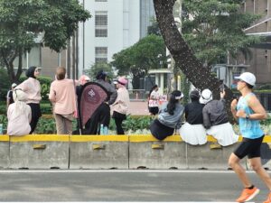 Perempuan berhijab beraktivitas di kawasan CFD Jakarta bersama warga lainnya.